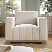 Beige armchair in a room with large windows and a plant